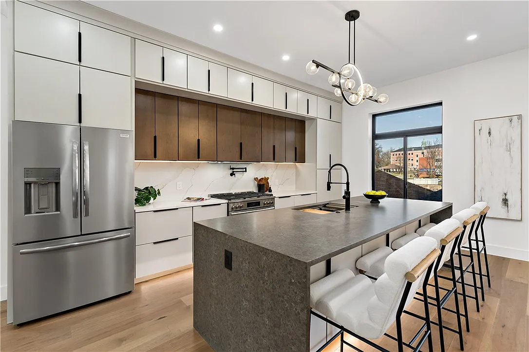 Maple Avenue kitchen with white cabinetry, wood accents and a waterfall island